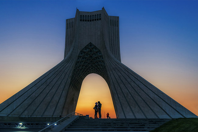 《自由塔》 作者：叶红兵，拍摄于伊朗德黑兰自由塔。在日落余晖的衬托下，自由塔的宏伟和独特的设计风格更加彰显。拱门下，一对恋人正叙述着全人类共同的美好愿望——自由与和平。