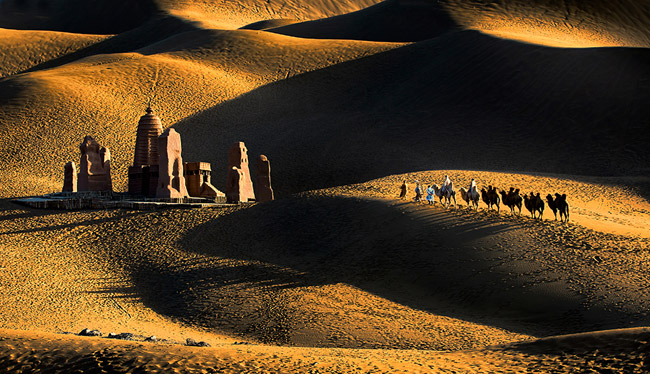 《久远的故事》 作者：朱红辉，拍摄于新疆鄯善。夕阳西下，驼队行走在沙漠之中，也把人们带入了那久远的故事。他们，穿越那条古老的丝绸之路，一步一个脚印，踏出了中国的昨天、今天与明天。